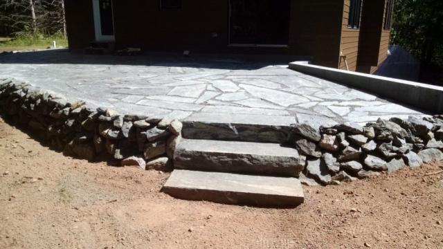 Aqua Grantique flagstone patio with steps and boulder retaining wall